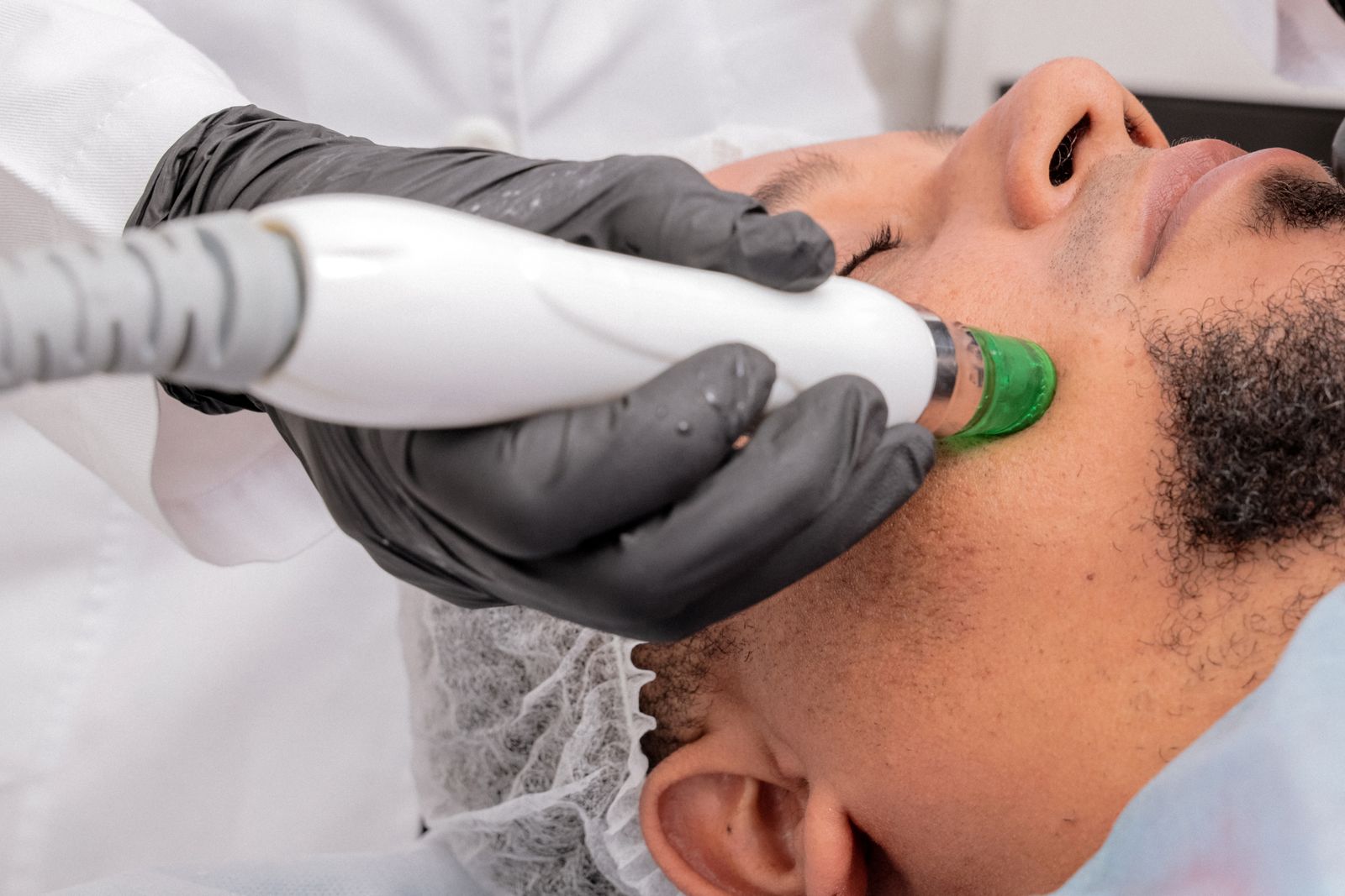 Editorial image of a professional facial treatment using skincare equipment.